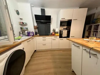a kitchen with white cabinets and a wooden floor at 2 pièces Cannes centre Terrasse et plage à 5 min in Cannes