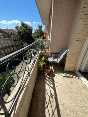 a balcony with a chair and plants on a building at 2 pièces Cannes centre Terrasse et plage à 5 min in Cannes