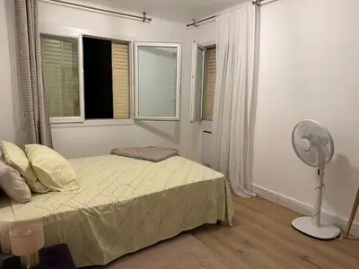 a bedroom with a bed and a fan and a window at 2 pièces Cannes centre Terrasse et plage à 5 min in Cannes