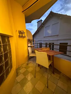 a small balcony with a wooden table and chairs at 2 pièces Cannes centre Terrasse et plage à 5 min in Cannes