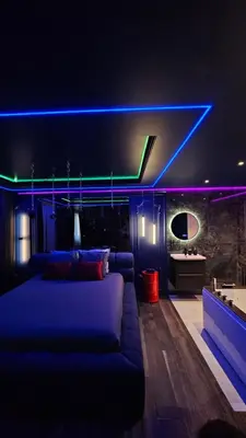 a living room with a couch and a blue light at Love room - Xtase By luxuria Cannes in Cannes