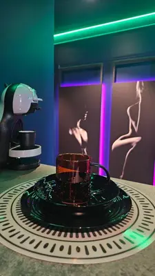 a black coffee cup on a plate on a table at Love room - Xtase By luxuria Cannes in Cannes