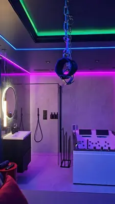 a room with purple and green lights and a bathroom at Love room - Xtase By luxuria Cannes in Cannes