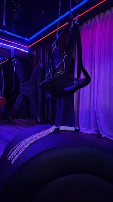 a stage with a pair of shoes hanging from the ceiling at Love room - Xtase By luxuria Cannes in Cannes