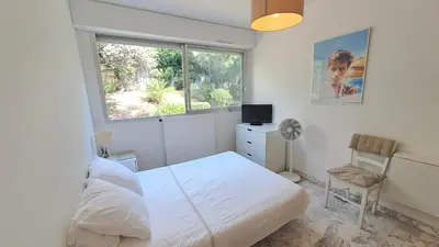 a bedroom with a bed and a window and a chair at Beau studio centre Cannes Maréchal Juin in Cannes