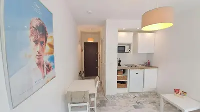 a kitchen with a large poster of a man on the wall at Beau studio centre Cannes Maréchal Juin in Cannes