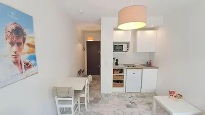 a kitchen and a living room with a table and chairs at Beau studio centre Cannes Maréchal Juin in Cannes