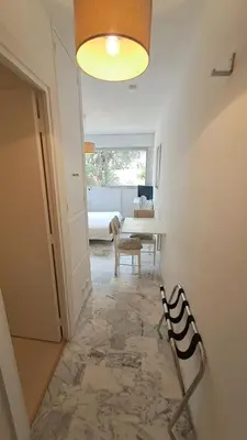 a hallway with a table and a chair in a room at Beau studio centre Cannes Maréchal Juin in Cannes