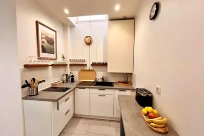 a kitchen with white cabinets and a bowl of fruit on a counter at Cannes centre - Forville Market in Cannes