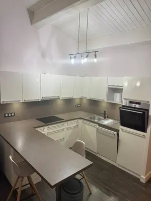 a kitchen with white cabinets and a table with chairs at The Mazet in Cannes