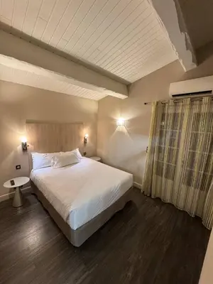 a bedroom with a large white bed and a window at The Mazet in Cannes