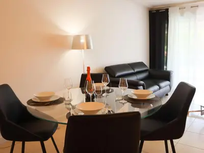 a dining room with a table with chairs and a couch at Apartment Cristal Croisette-5 by Interhome in Cannes