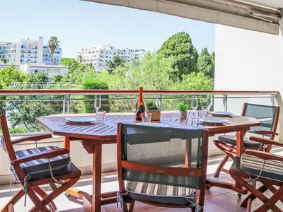 a table with chairs and a bottle of wine on a balcony at Apartment Cristal Croisette-5 by Interhome in Cannes