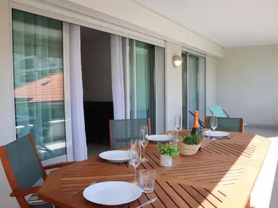 a wooden table with plates and glasses on a balcony at Apartment Cristal Croisette-5 by Interhome in Cannes