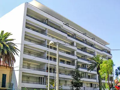 a large white building with palm trees in front of it at Apartment Cristal Croisette-5 by Interhome in Cannes