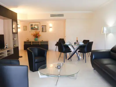 a living room with a table and black chairs at Apartment Cristal Croisette-5 by Interhome in Cannes