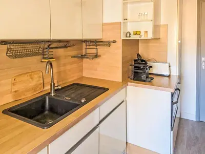 a kitchen with white cabinets and a sink at Apartment La Chaumière by Interhome in Cannes