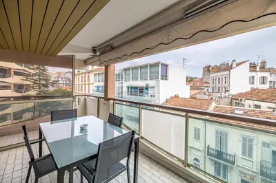 a table and chairs on a balcony with a view at LE CHATAIGNIER avec terrasse au calme et central in Cannes