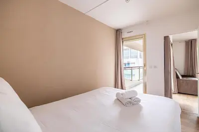 a bedroom with a bed with two towels on it at LE CHATAIGNIER avec terrasse au calme et central in Cannes