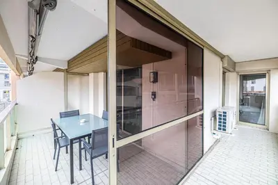 a dining room with a table and a glass wall at LE CHATAIGNIER avec terrasse au calme et central in Cannes