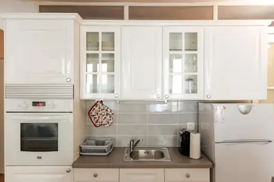 a kitchen with white cabinets and a sink at Le Meynadier Center-Festival-Clim-WiFi in Cannes