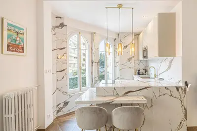 a kitchen with a marble counter and two stools at LE PASTEUR pour tout confort en plein cœur de Cannes in Cannes