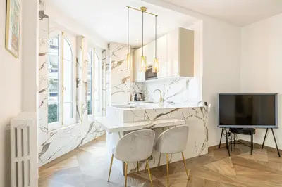 a kitchen with a marble counter and two chairs at LE PASTEUR pour tout confort en plein cœur de Cannes in Cannes