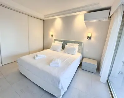 a bedroom with a white bed with two towels on it at Elegant 2 Br with parking in Cannes