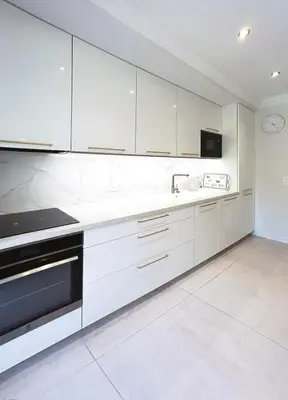 a white kitchen with white cabinets and a sink at Elegant 2 Br with parking in Cannes