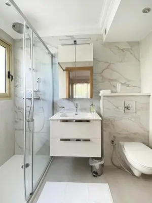 a bathroom with a shower and a sink and a toilet at Elegant 2 Br with parking in Cannes