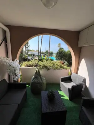 a living room with a large window and green carpet at Appartement 2 pièces Cannes - Piscine - Plages in Cannes