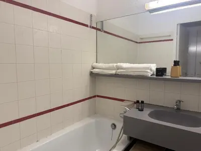 a bathroom with a tub and a sink and a mirror at Appartement 2 pièces Cannes - Piscine - Plages in Cannes
