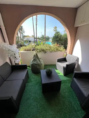 a patio with green grass and chairs and an archway at Appartement 2 pièces Cannes - Piscine - Plages in Cannes