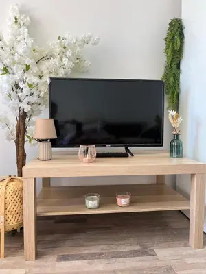 a television on a wooden entertainment center in a living room at Appartement 2 pièces Cannes - Piscine - Plages in Cannes