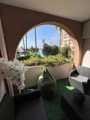 a living room with a large window with a view of a pool at Appartement 2 pièces Cannes - Piscine - Plages in Cannes
