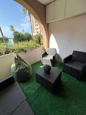 a living room with chairs and a green carpet at Appartement 2 pièces Cannes - Piscine - Plages in Cannes