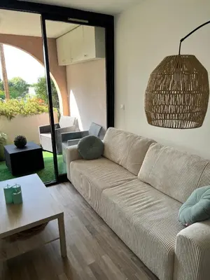 a living room with a couch and a table at Appartement 2 pièces Cannes - Piscine - Plages in Cannes