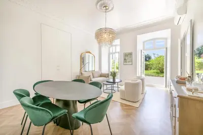 a dining room with a table and green chairs at LB Vacation Rentals I Luxurious 1BR with parking & terrace in Cannes