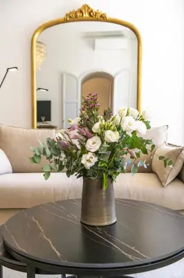 a vase with flowers on a table in a living room at LB Vacation Rentals I Luxurious 1BR with parking & terrace in Cannes