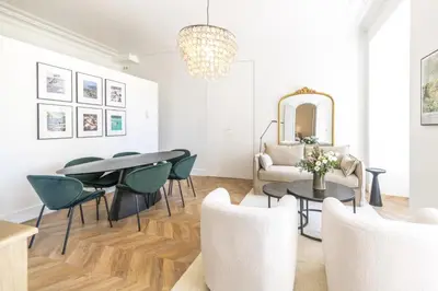 a living room with a table and chairs and a chandelier at LB Vacation Rentals I Luxurious 1BR with parking & terrace in Cannes