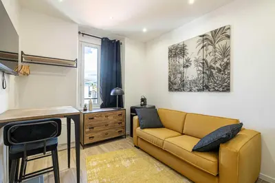 a living room with a blue couch and a window at Renovated cozy studio in Cannes - 2 persons in Cannes
