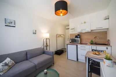 a living room with a couch and a kitchen at Studette Croisette, proche Martinez in Cannes