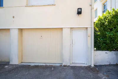 a white building with two garage doors on it at Studette Croisette, proche Martinez in Cannes