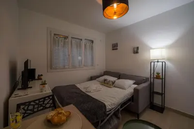 a small bedroom with a bed and a table at Studette Croisette, proche Martinez in Cannes