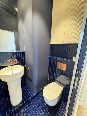 a blue tiled bathroom with a toilet and a sink at Brand-new 100 sqm apartment with breathtaking panoramic views over Cannes’ in Cannes