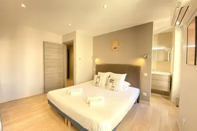 a bedroom with a large bed with white sheets and pillows at Stylish 2 Bed Apartment 1 Min to Palais & Beach in Cannes