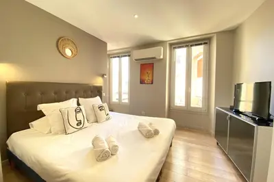 a bedroom with a bed with two slippers on it at Stylish 2 Bed Apartment 1 Min to Palais & Beach in Cannes