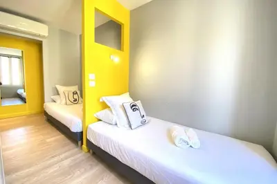 two beds in a room with yellow and white at Stylish 2 Bed Apartment 1 Min to Palais & Beach in Cannes
