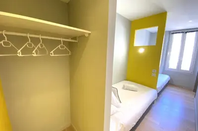 a small room with yellow walls and a shelf with hangers at Stylish 2 Bed Apartment 1 Min to Palais & Beach in Cannes