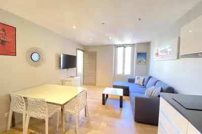 a living room with a blue couch and a table at Stylish 2 Bed Apartment 1 Min to Palais & Beach in Cannes